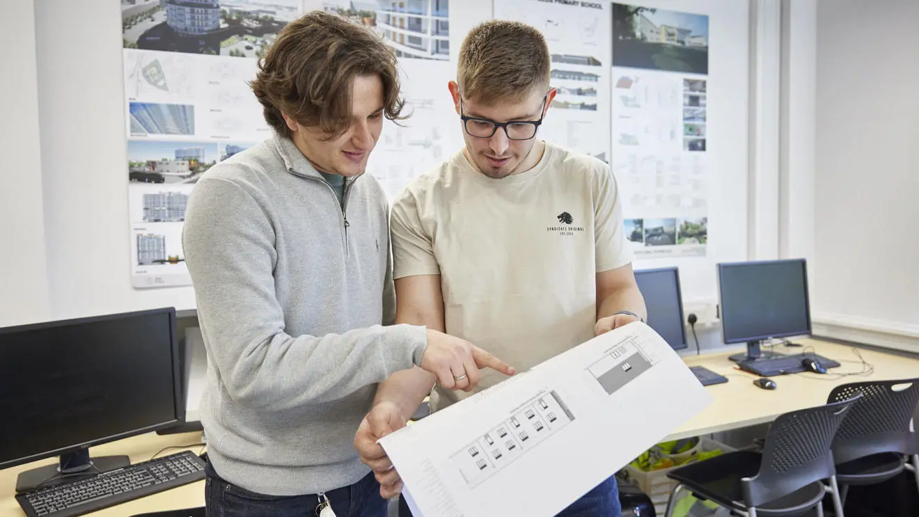 Two architecture students looking at drawings