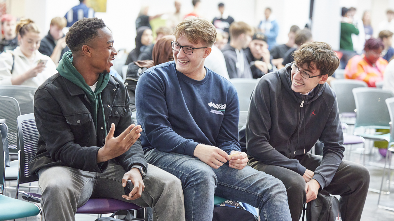 Three students sat together laughing