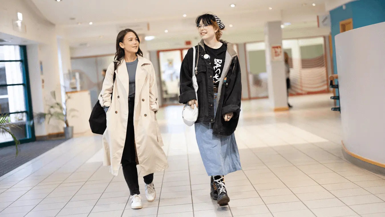 Two students walking through the Andrews concourse