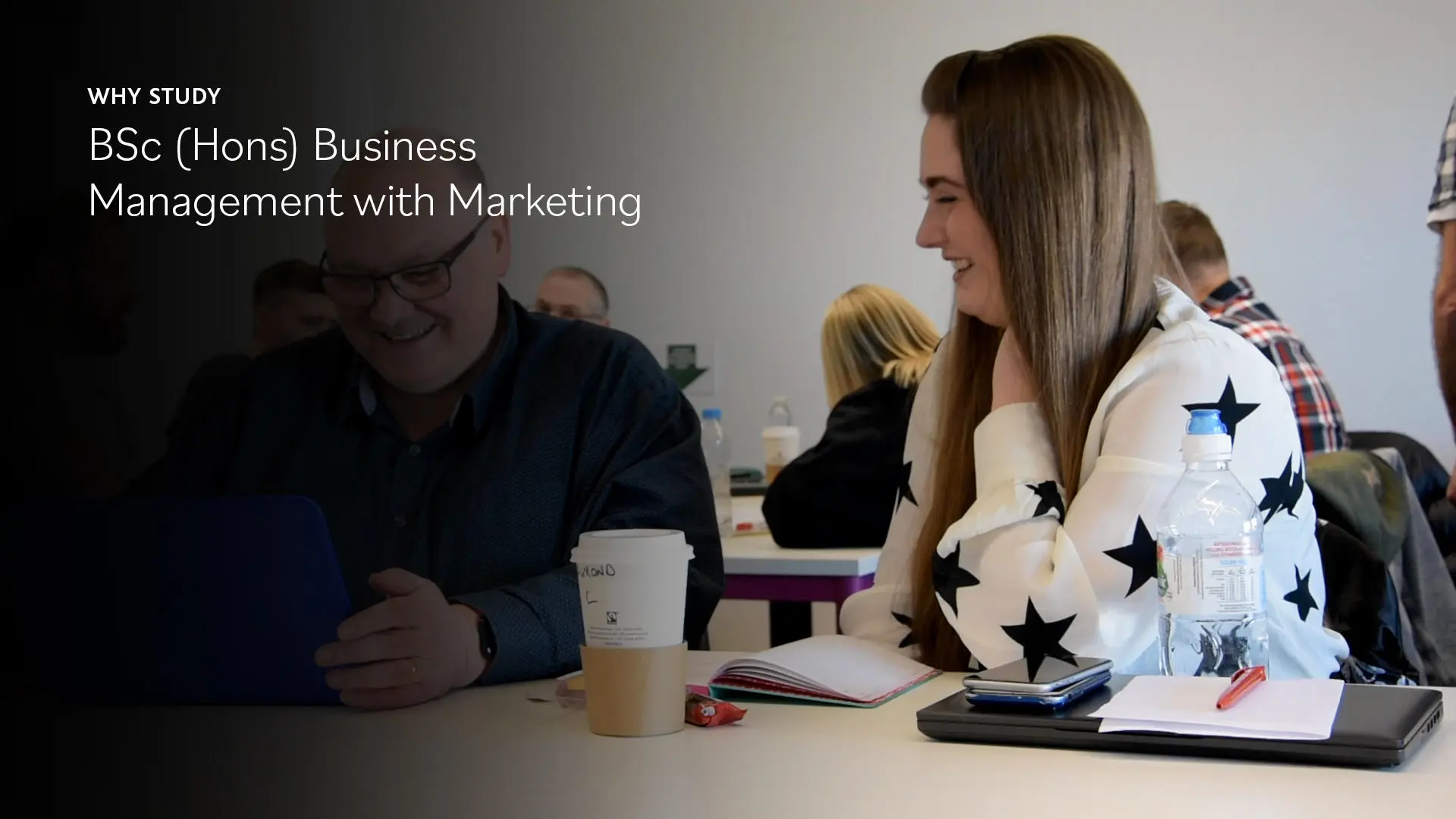 Image of student sitting at a desk in university, with text saying: 'Why study BSc (Hons) Business Management with Marketing