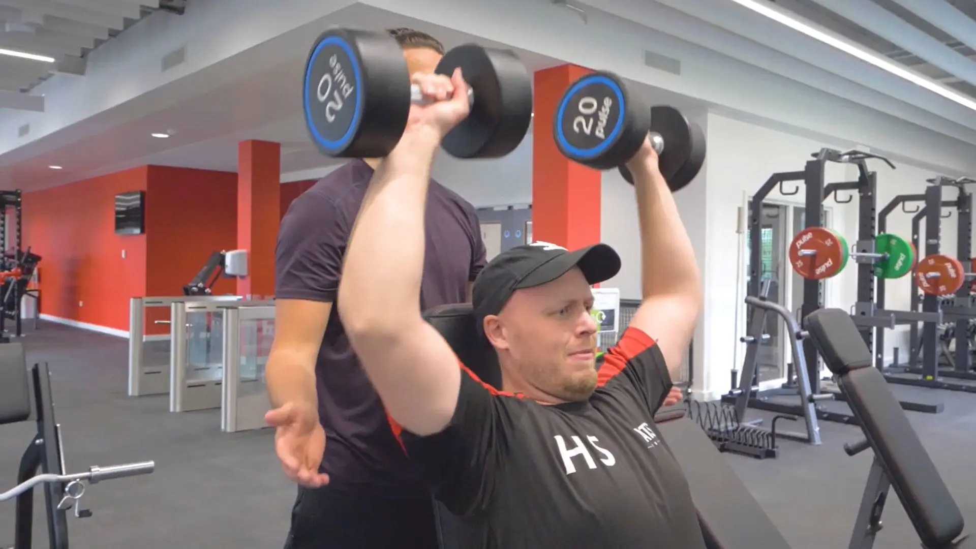 A person lifting hand weights in the gym