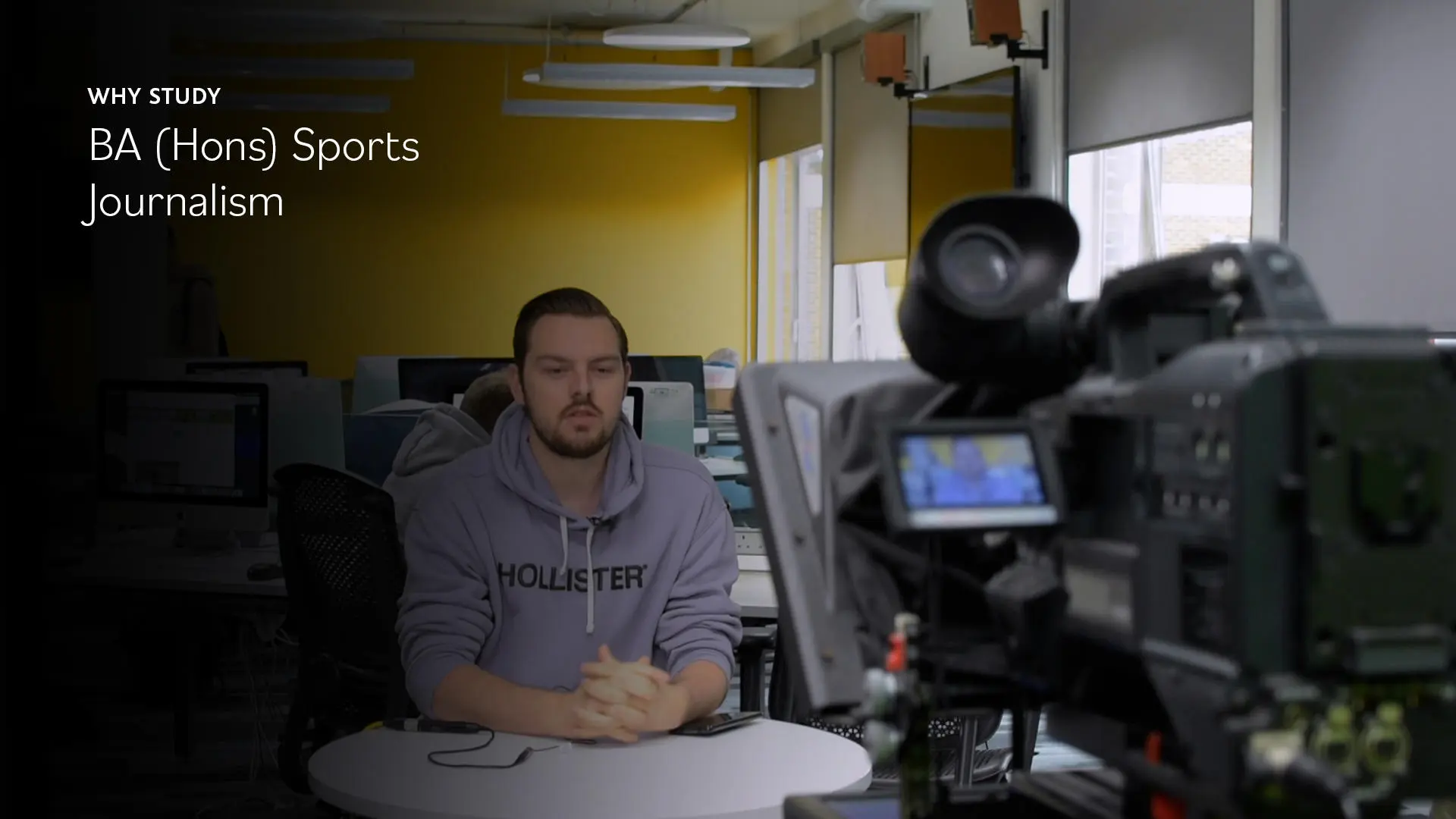 Image of student presenting to camera in the newsroom at university