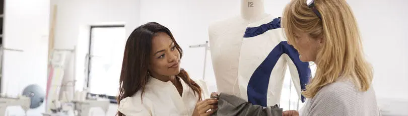 A student with a lecturer in the fashion design studio