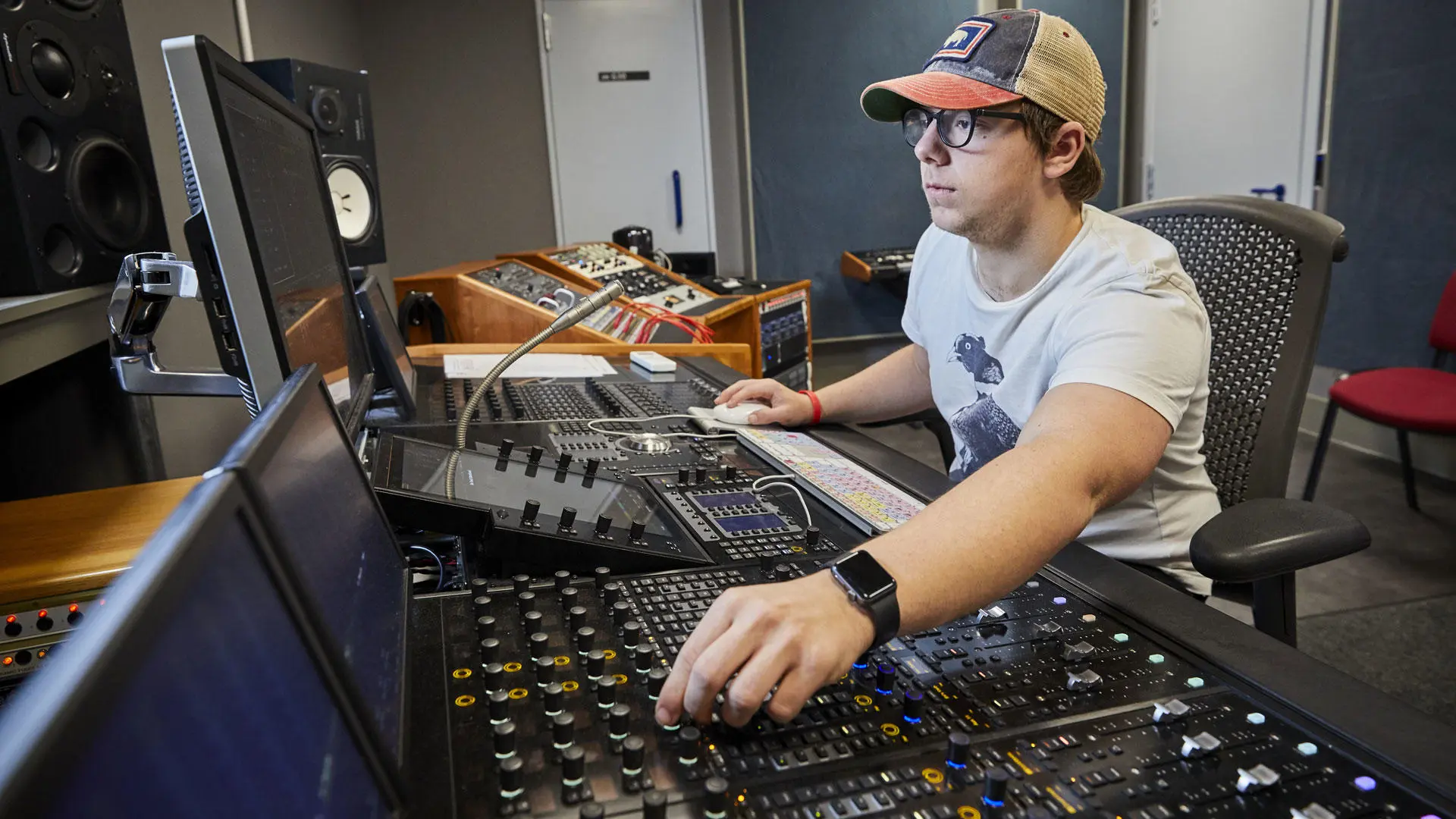 A popular music production student at a mixing desk