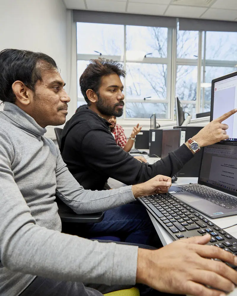 Two computing students working on a computer