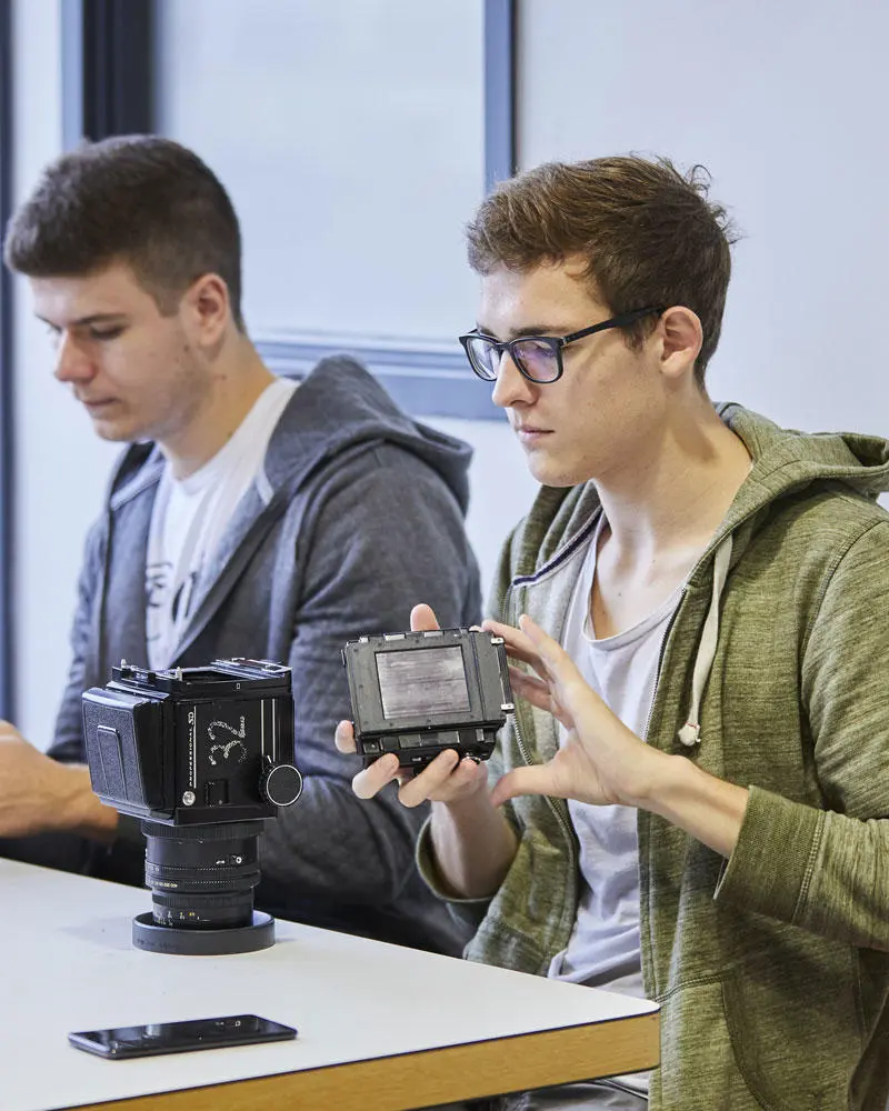 Media foundation year students assembling a camera