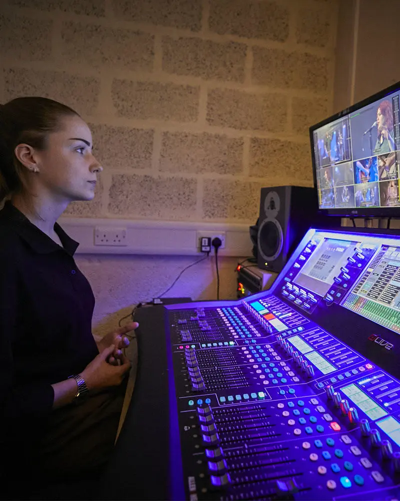 A music production student at a mixing desk