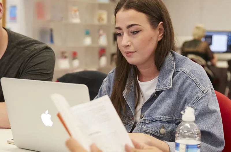 Students on a laptop in the library