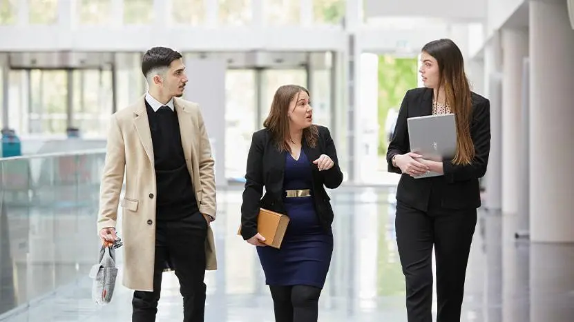 Image shows three students in business dress in Solent's Spark building