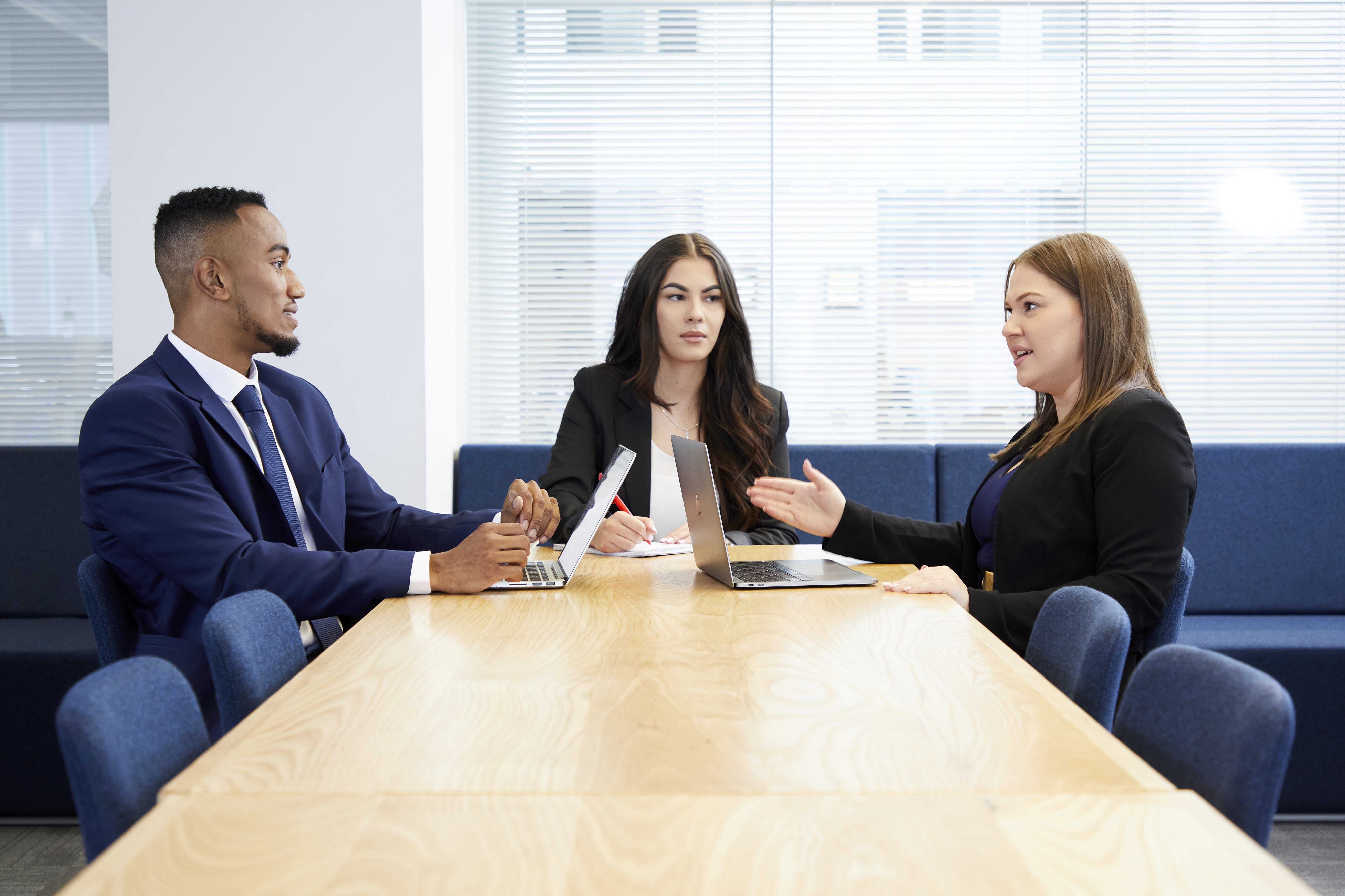 Image of three people working at a desk in a corporate environment