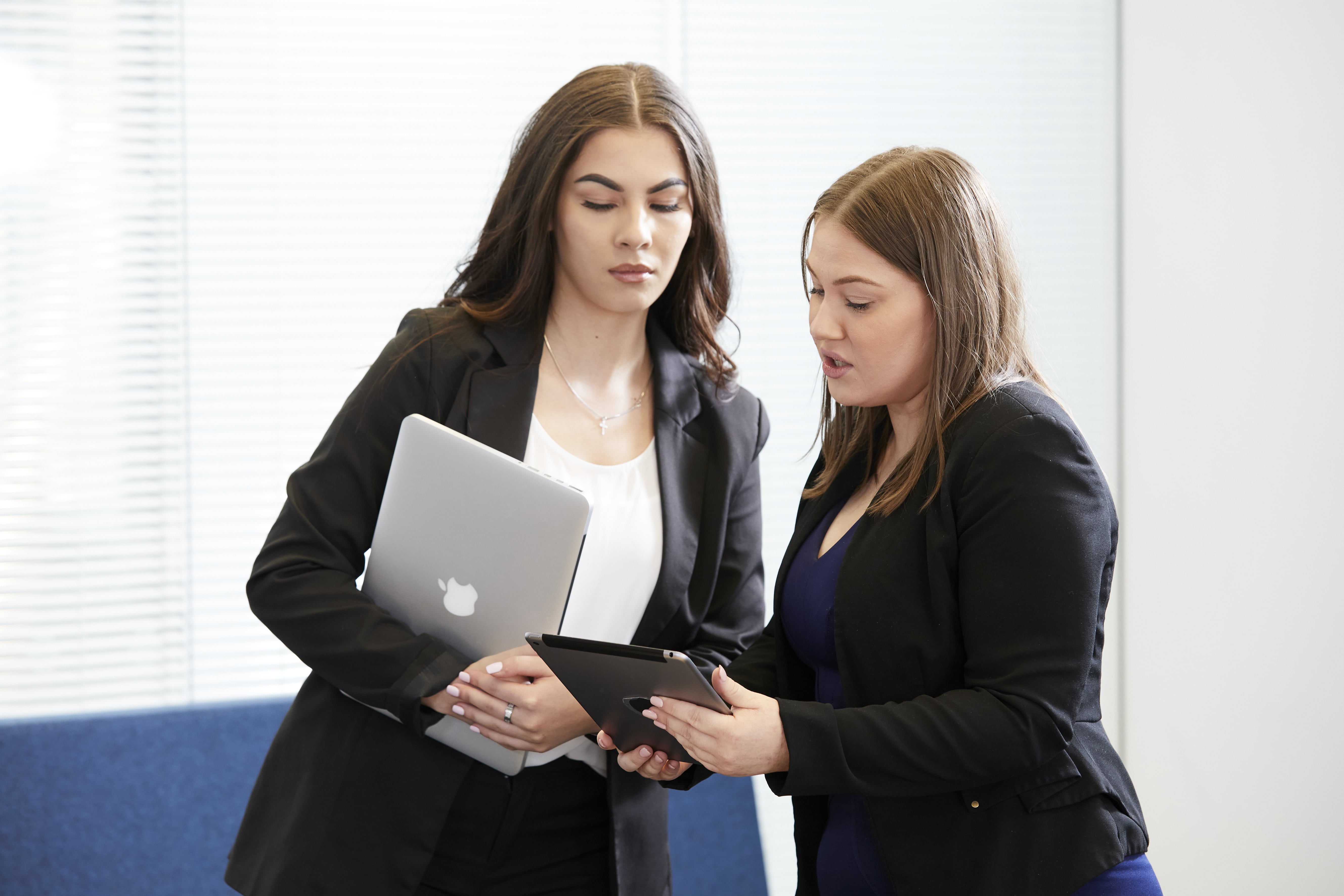 Image of two office workers looking at a laptop