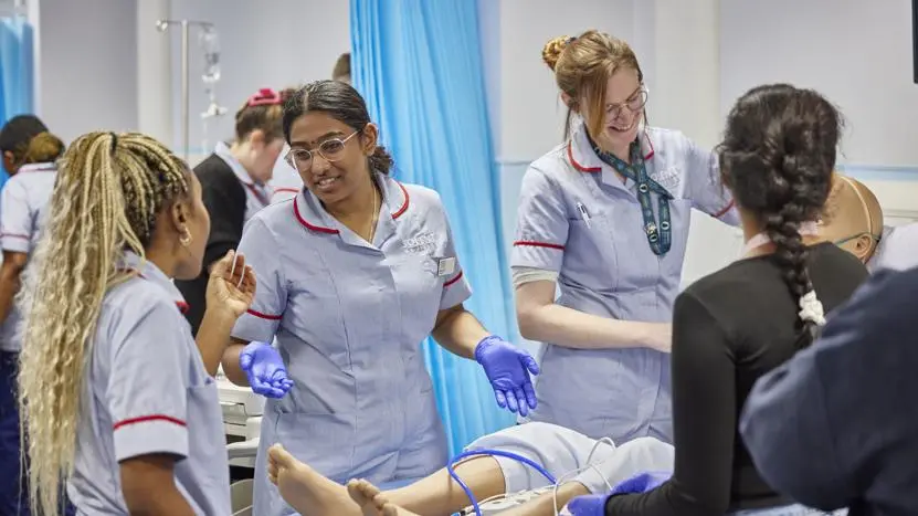 Health professionals working in a nursing simulation suite