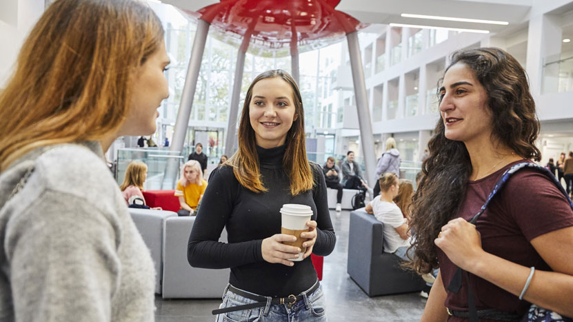 Three female students talking to each other in The Spark