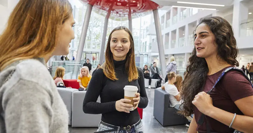 Three female students talking to each other in The Spark