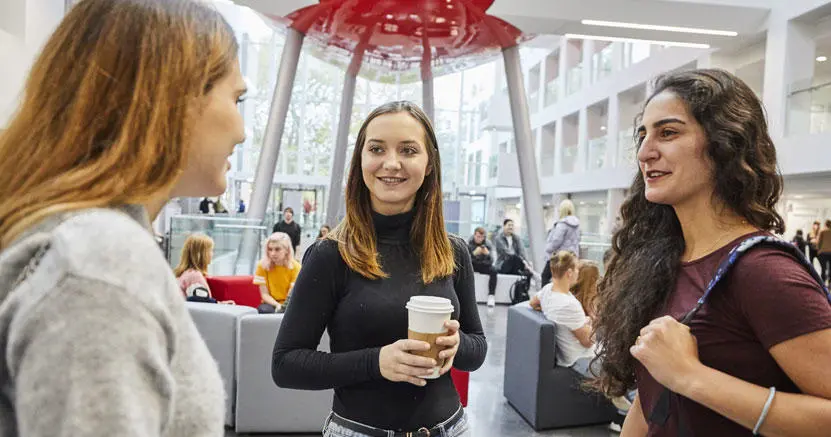 Three female students talking to each other in The Spark