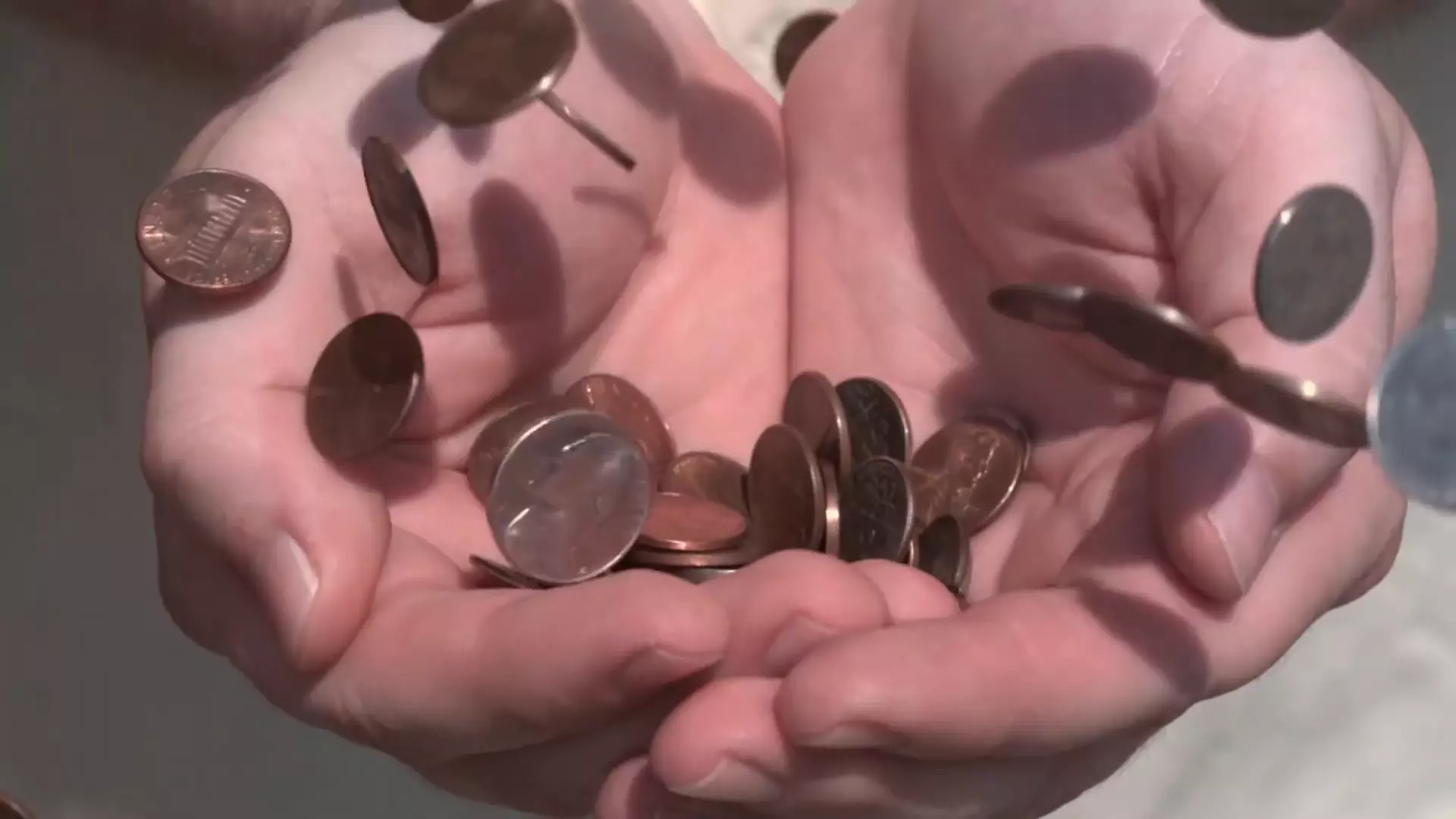 Coins dropping into a persons hands