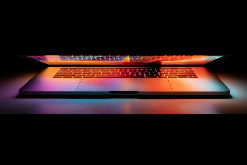 A half-closed laptop giving off an orange glow
