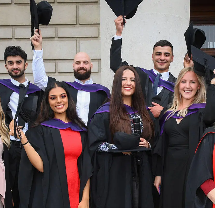 A group of graduates smiling at the camera