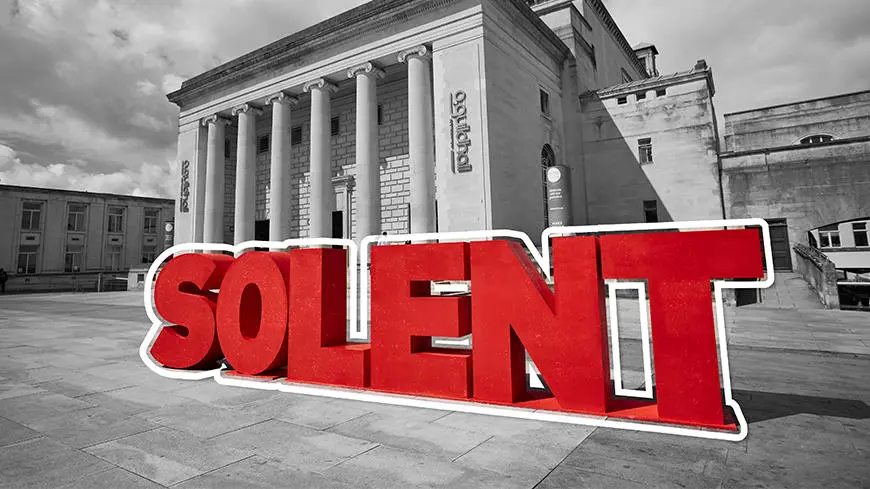 Big, bright red letters spelling SOLENT with a black and white image of the Guildhall