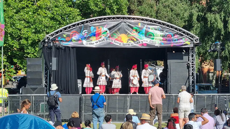 A group of Asian musicians performing on stage at an outdoor event