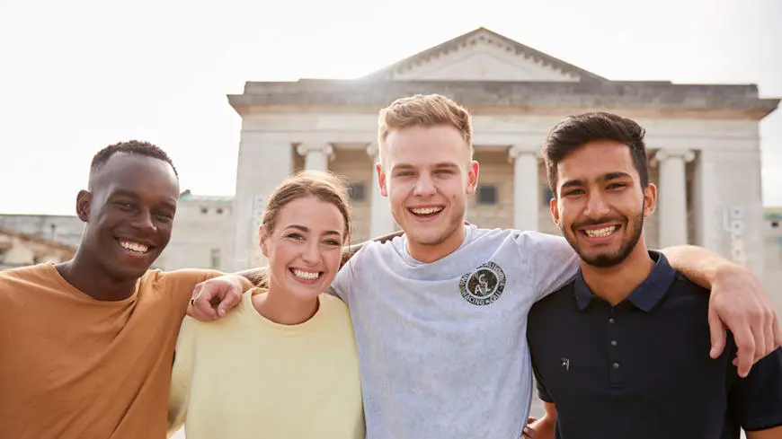 Four students smiling to camera in Southampton Guildhall Square
