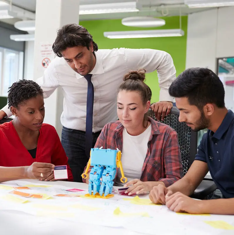 Students with a lecturer working with a toy robot