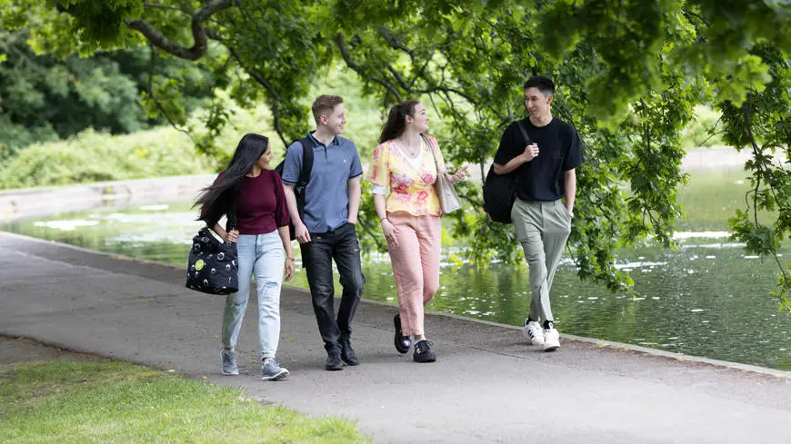 Four students walking through the park