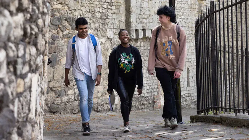 Three Solent students walking through the old walls in Southampton