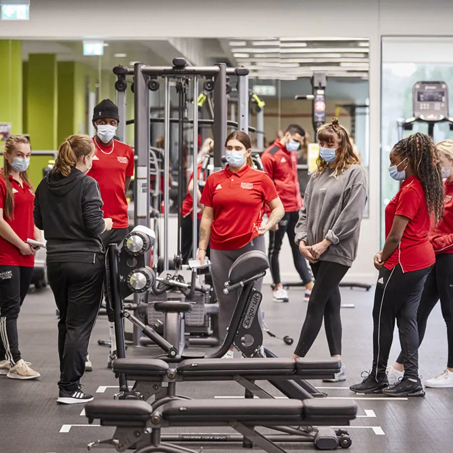 A group of sport students in the gym wearing face masks