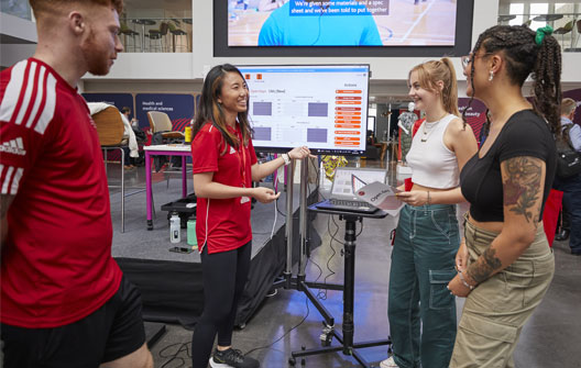 Students in discussion beside a screen