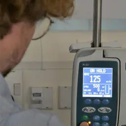 A nursing student looking at a blood pressure monitor