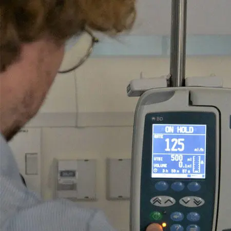 A nursing student looking at a blood pressure monitor