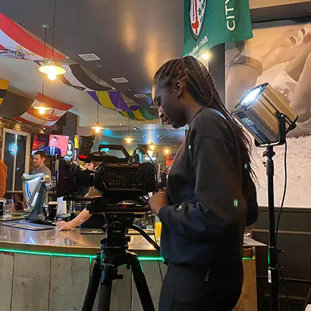 Peace Olabode operating a camera