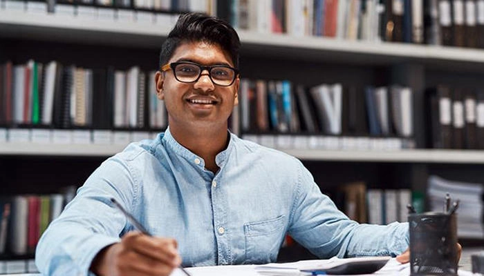 A male student working in a text book