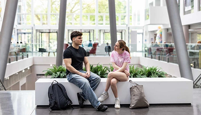 Two students talking to each other in the Spark atrium