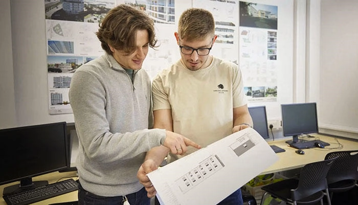 Two architecture students looking at drawings