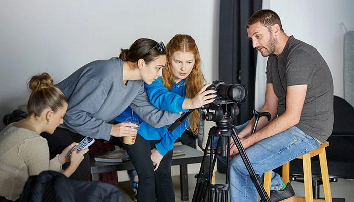 Photography students looking at a camera