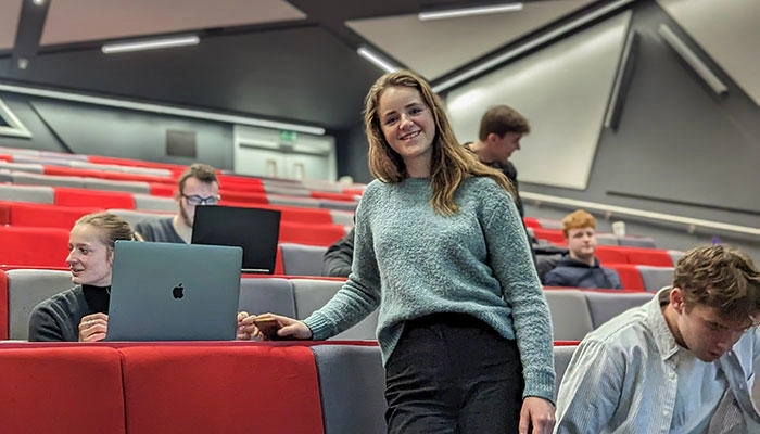 A business management studio in the lecture theatre smiling at the camera