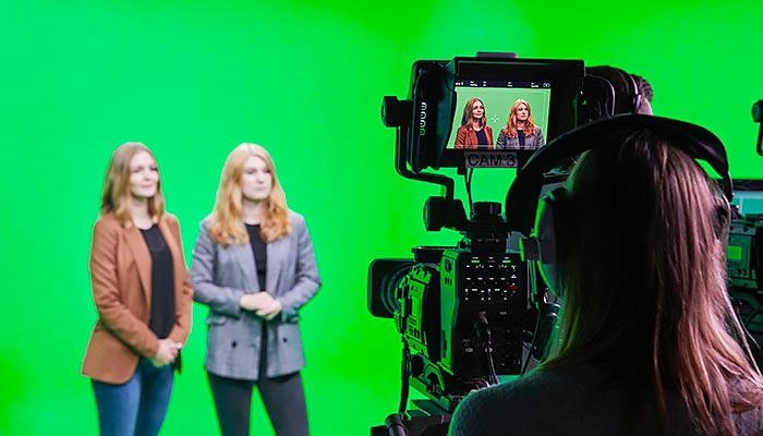 Students in the tv studios in front of a green screen