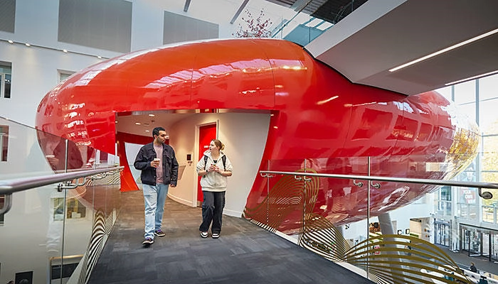 Two students walking along the bridge on the Pod