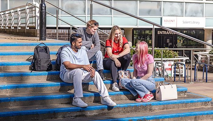 A group of students sat on steps outside the library