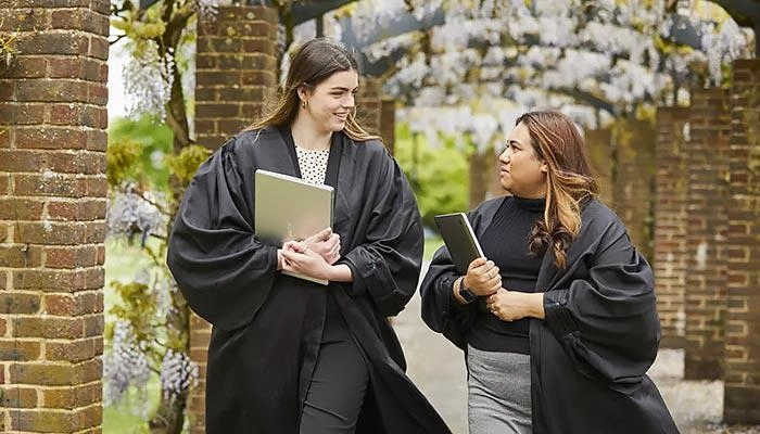 Law students wearing robes, walking through the park