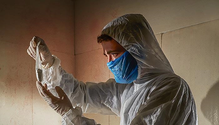 A student wearing PPE looking at evidence