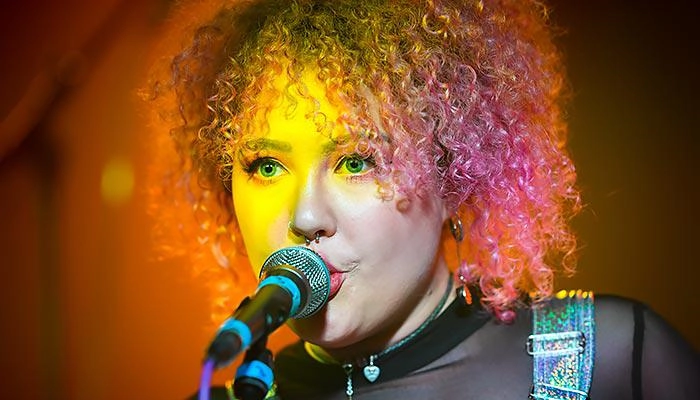 A music performance student singing into a microphone