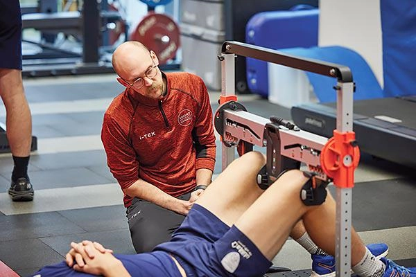 A sport science student working with a client in the gym