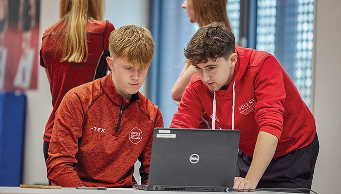Sport science students looking at a laptop