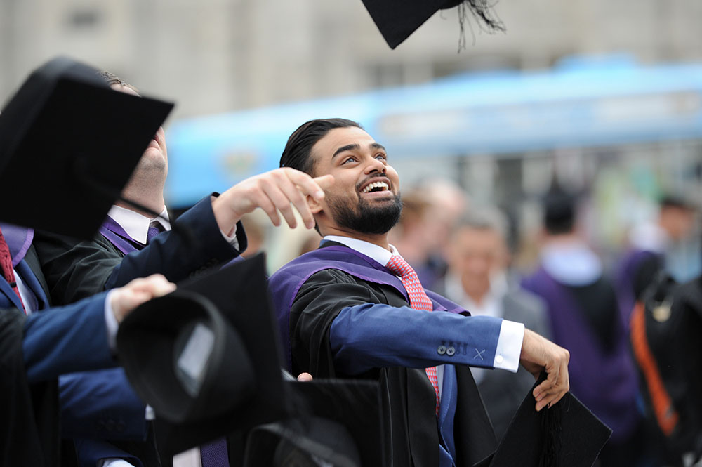 Solent University graduate throwing hat in the air
