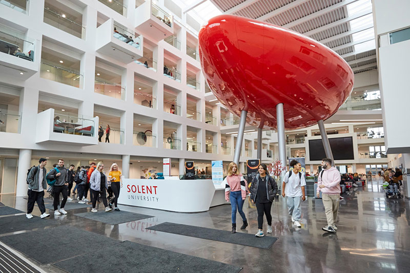 Students walking through the Spark with the pod in the background