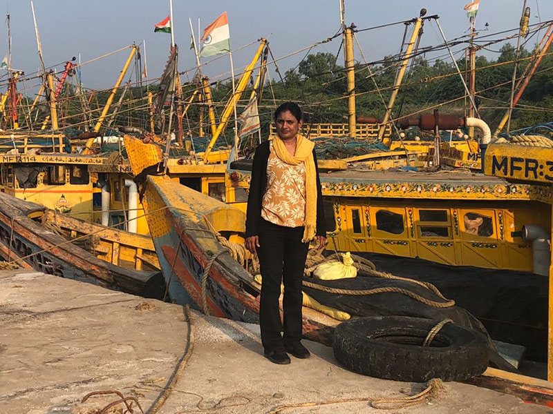 Dr Komali Kantamaneni stood in front of boats as part of the GCRF project