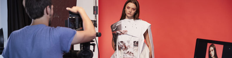 A fashion photography student taking photos of a model in the studio